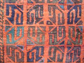 Baluch Main Carpet with Reciprocal Gul Grid. In Praise of Visual Imagination: Granted that thumbnail views can only suggest the truth. But surely someone will be able to envision this compact yet expansive main carpet in all her coloristic glory and calm majesty of design, recognizing the anonymous genius whose fingers transferred the powers of the mind\'s eye into this robust, dynamically tensile reciprocal gridwork of unusual Guls in dark tones with electrifying flashes of Blues on a smouldering crimson field. Purists of Dye Chemistry Beware: the 3 small light triangles in the field may contain (horrors!) fuchsine. 132 x 213 cm.