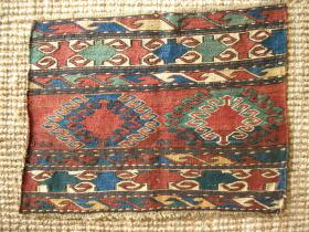 Mafrash end panel, Southern Caucasus, 51 x 40 cms, glossy wool, colours: the red is unusually dark, in places approaching purple-red, the light blue/green was a dark green (see back side image), golds were also darker; no repairs; a similar border design can be seen in Azadi/Andrews, Mafrash, p. 102; a strangely abstract piece with un-ornamented motifs.