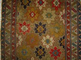  Shirvan Baku Snowflake Ppalmettes long rug, sides rough, soul intact, 31 humanoids scattered in camel-color, eccentrically abrash-ed field.