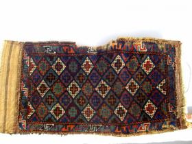  RARE, ANTIQUE BELOUCH PILLOW FACE.  I found this piece in Peshawar and there is no doubt that it has been used as a pillow or cushion rather than a storage bag. Because it has been in use it is worn around the edges although decent parts of the original kelims remain. The wool is lustrous and the colours deep and intense. I have seen one other Belouch piece - which was a small prayer rug - with these colours and the same weave. Late 19th / early 20th century.  Reference 296.   75 x 45cms. �350.
 