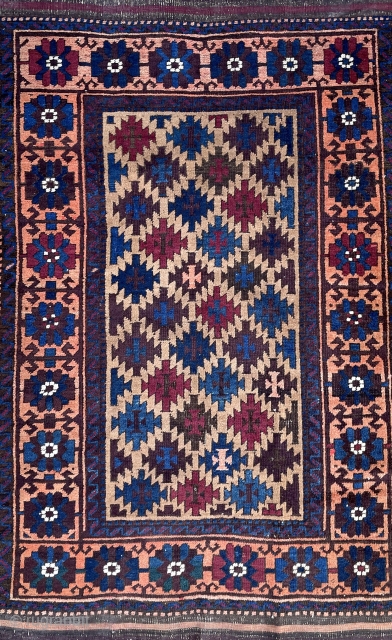 Antique symmetrical knotted Baluch rug. Great colors and and uncommon well planned border. The field is camel wool. 2'10" x 5'0" or 87 x 153cm.        