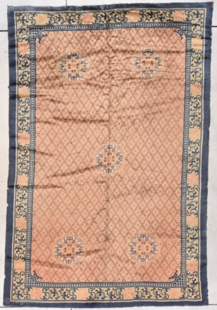 This first half 19th-century Peking Chinese rug measures 5’10’ x 8’9”.  It has a diamond design on a peachy coppery ground with five medallions, each consisting of four bats facing inward  ...