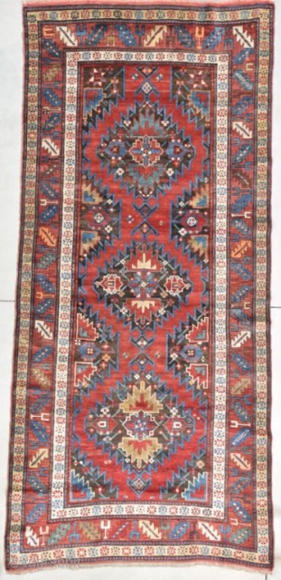 This circa 1875 Gallery sized Kazak #8105 measures 4’7” X 10’4”. It has a very strange and complicated design. There are three medallions on a black ground. The medallions contain three different  ...