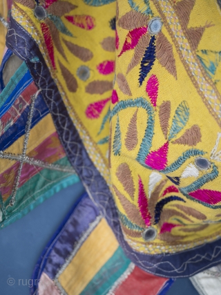 Rare and very large festival toran/tent banner, 450cm x 42cm (177 x 16.5 inches). Hand embroidered in vibrant pinks and greens on a beautiful Saffron ground. Gujurat, circa 1940.

The pennants, stitched together  ...