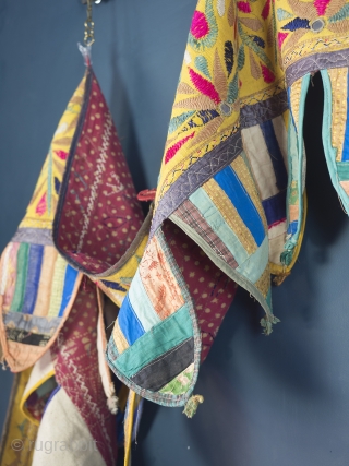 Rare and very large festival toran/tent banner, 450cm x 42cm (177 x 16.5 inches). Hand embroidered in vibrant pinks and greens on a beautiful Saffron ground. Gujurat, circa 1940.

The pennants, stitched together  ...