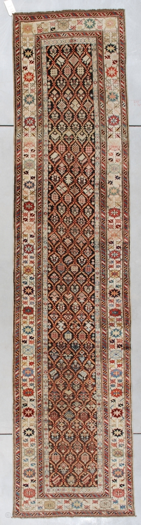 This circa 1875 Kuba Runner #7414 measures 3’2” X 13’2” (97 x 401 cm). This is an interesting long rug. It has a latticework design containing innumerable different flower motifs worked in  ...