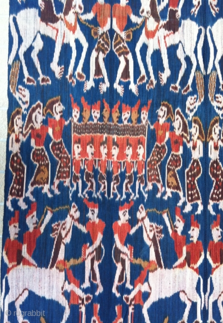 Outstanding example of Sumba Hinggi Ikat. A festive ceremonial parade. Large group of people riding on horses and parading while other people carrying an ark field with ladies, on their shoulders. Other  ...