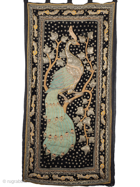 Antique Zardozi Peacock Wall Hanging

The heavily padded peacock stands proud of the black velvet ground and is rendered in gold and silver wrapped turquoise silk threads. Enclosed by multiple decorative borders and  ...