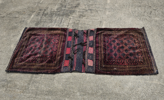 Baluch saddle bags, hand knotted wool pile, plain weave wool back, goat hair closure loops and selvage, moth damage, mostly to the back with holes and foundation threads showing, needs cleaning, the  ...