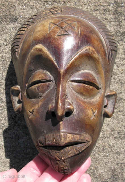 Vintage African mask, hand carved wood, Baule People, Ivory Coast, exhibiting facial scarification, a small mask like this would be used as a central feature of an elaborate mask, expanded with raffia,  ...