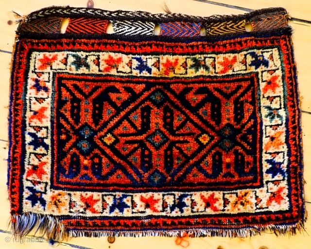 A small late 19th century Afshar bagface size 50 x37cm including closure loops

A bold and unusual design with a typical Afshar main border in good overall condition with a bite from the  ...