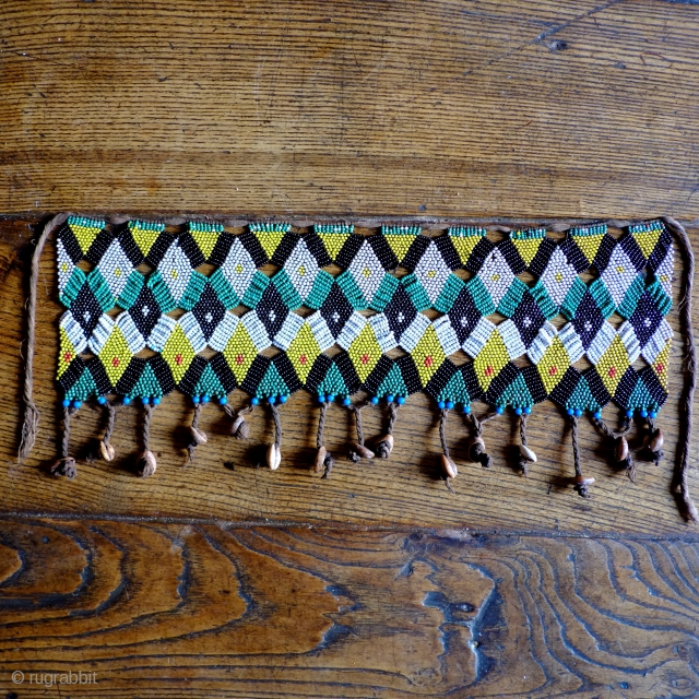 An early 20th century Cameroonian 'cache-sexe', with complex almost lace like 'offset' construction.Seed beads, cowrie shells and cotton string. Size 50 x 15cm.          