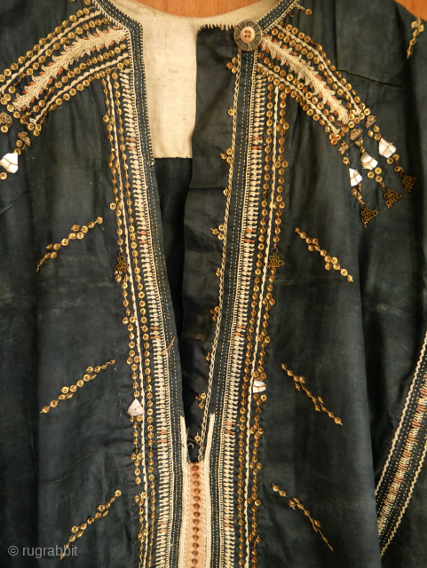 Rare Yemen bridal or festive dress (zanna) made of indigo dyed cotton, decorated with a variety of small, applied metal discs, metal chains, pieces of shell, as well as various embroidery stitches.  ...