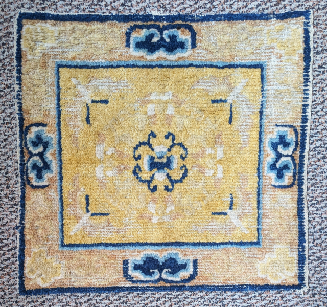 Small Chinese Ningxia square with clouds in the border and butterflies in the corners of the field.                