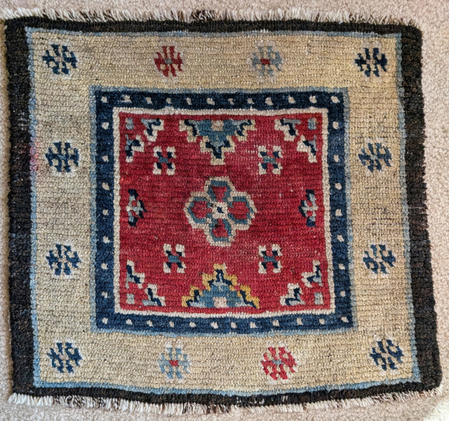 Tibetan square with a pale yellow border and red field with a textile pattern. All vegetable dyes.                