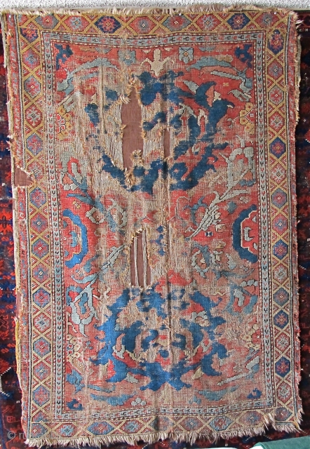 Smyrna small format carpet, probably 18th century, obvious damage, mounted on brown textile. Big knots, depressed warp, subtle color with two yellows and several blue-greens. (size is 6'3"x4'1")     