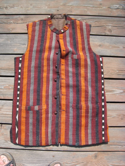 Man's vest tailored in Peshawar Pakistan of Kilim.  42 + inches across chest, 31 inches long.  Lined with khaki cotton.  woven leather buttons.       