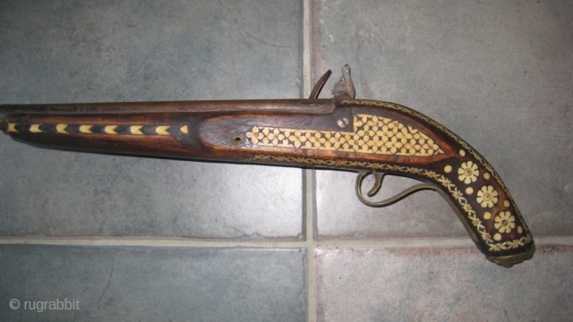 Antique decorated pistol from Tribal area of Pakistan. 18 inches long.  Wood and metal inlaid with bone.  Brass plate on barrel. Purchased in 1960's in NWFP, Pakistan.    