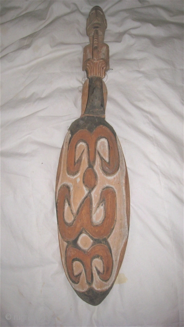 Asmat (West Papua) sago dish in shape of spear.  Male figure on handle holding a bird.  25 inches long, 7 inches wide.  Purchased in Irian Jaya in 1985.  