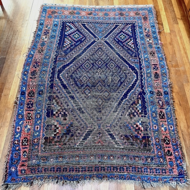 A very old Kurdish carpet, used too long on the floor, but potentially restorable. 76 inches x 52 inches (at widest), or 193 cm x 132 cm.  Pile ranging from good  ...