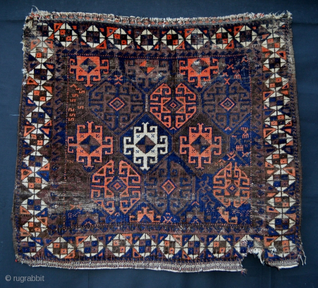 Antique Baluch bagface 79cm x 68cm (2' 7" x 2' 3") with some wear and bite out of the lower right border, but with an interesting and archaic field and border design. 