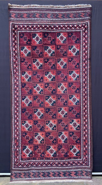 Baluch rug with overall design of Turkmen 'ayna' guls in full pile with complete plain-weave skirts - 2.44m x 1.17m (8' 0" x 3' 10").        