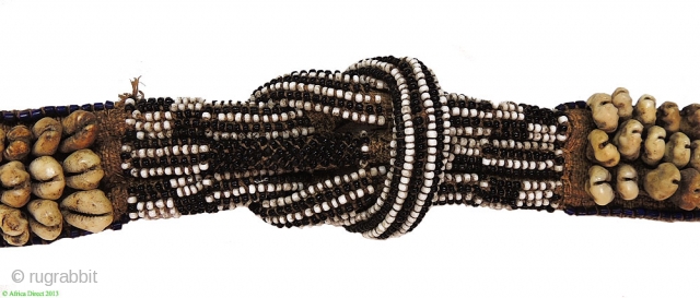 Kuba people belt (mukody mu-ikup lakiing). Congo. First half 20th century. A wonderful tribal art example made of raffia, cowry shells and glass beads. 
These objects were worn in ceremonial and funerary  ...