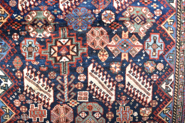 An antique Shekarlu Qasgai rug of unusual small size. Typical design, with a riot of colourful filler elements framed by sunburst borders. A good tribal rug this, with fine silky wool and  ...