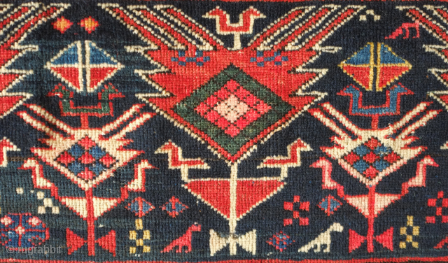 Shirvan rug, 19th century.  Botehs and shrubs of life or shrubbery of a general nature flanked by birds.  The weave is fine.  A section of wear in one of  ...
