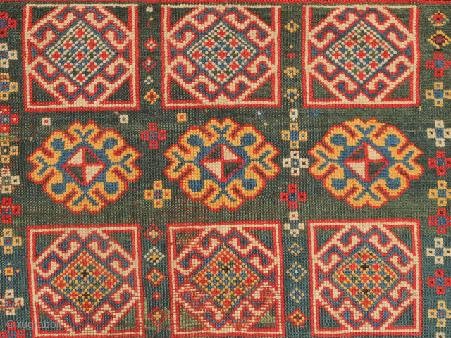 Genje green ground rug, 19th century. Wonderful large florets and hooked medallions in the field. Some old repairs here and there. Some lower pile areas. 94 x 180 cm