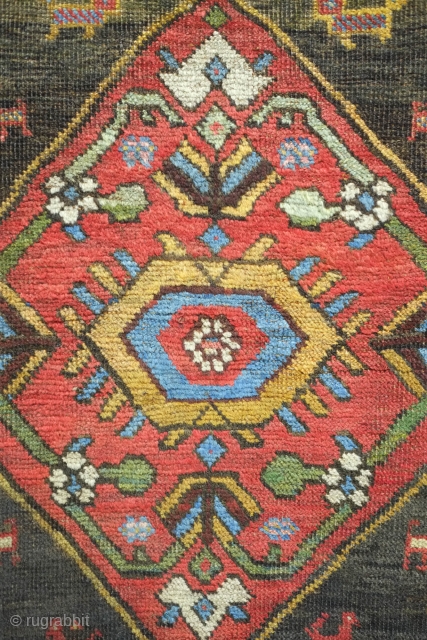 Bijar rug, 19th century.  Vivid colors, abstract pendants with rings of colors and human and small animal figures littering the field.  128 x 156 cm      