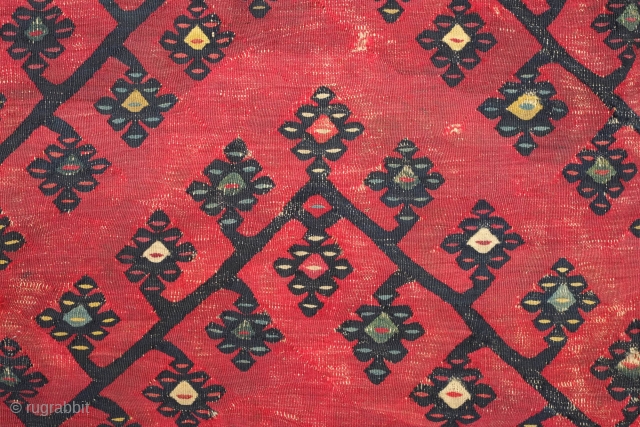 Sarkoy kilim, 19th century.  Beautiful saturated cochineal ground with zigzagging branches.  Playful animalistic floral motifs along the white borders.  A kilim that resonates despite its obvious damage.  334  ...