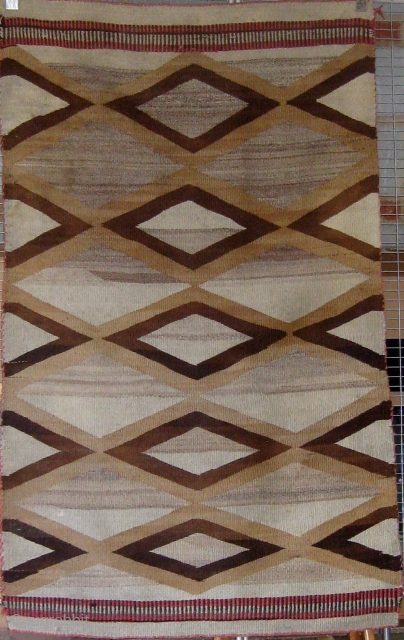 Antique Navajo weaving (first quarter of the 20th century) incorporating both tapestry and twill weave, 39" by 65", natural wool colors with aniline dyed red wool.       