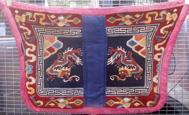 Antique butterfly-shaped Tibetan saddle cover or rug, dragons and mountains on a deep blue field in a spare design usually associated with earlier examples.  Early 20th Century. Traditional red edging (faded)  ...