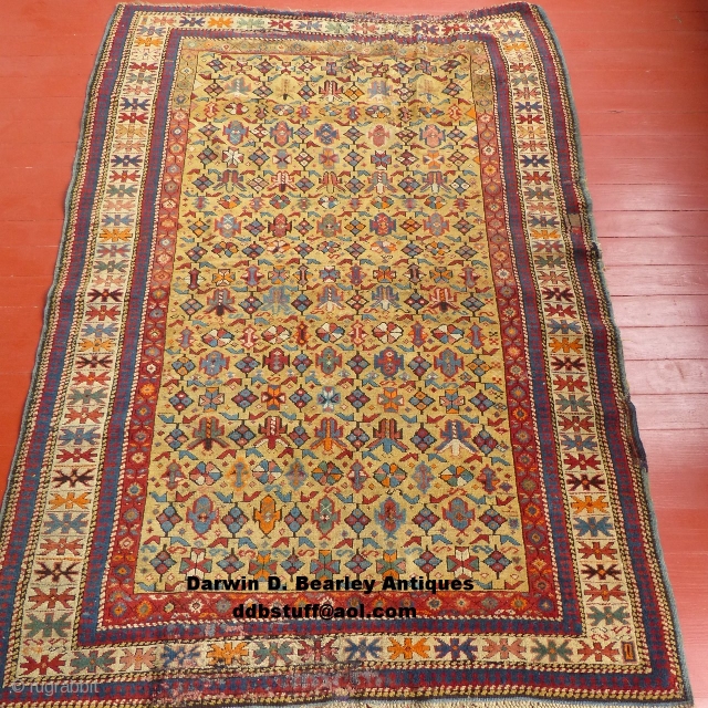 This is a great Caucasian Kuba.
It has a beautiful gold colored field and nice design.
However, it does have it's share of problems.
Both end areas have damage and very poor repairs.
The pile is  ...