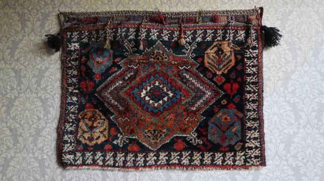 A dark blue central field with a large flattened hexaeder in it s middle. The central border comprised a double bird motif. Khorjin front . ca; 69 cm. x 88 cm.   ...