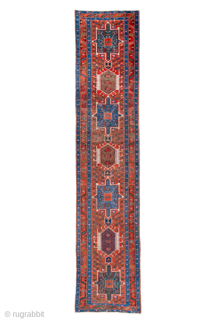 Antique Persian Heriz Runner, circa 1910. Bold geometric medallions in deep red and indigo with ivory accents, framed by a classic angular Heriz border. Strong village weave, ideal for a long hallway  ...