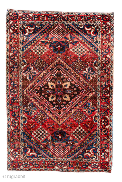 Antique Persian Bakhtiari Rug, circa 1920. Featuring a bold diamond medallion on a rich red field with indigo and ivory accents, framed by a lively floral border. Strong tribal character with vibrant, ...