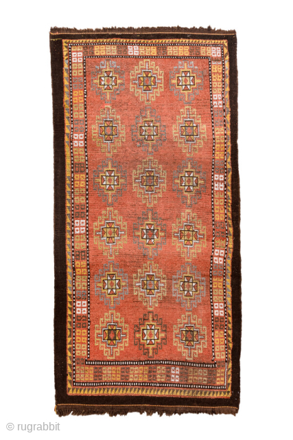 Antique Persian Kurdish Rug, circa 1920. Featuring an allover geometric star motif on a warm coral field with soft ivory and blue accents, framed by simple tribal borders. Bold village weaving with  ...