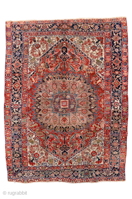 Antique Persian Heriz Carpet, circa 1900. Featuring a dramatic geometric medallion on an ivory field with rich red and deep indigo accents, framed by a bold Heriz border. Classic Northwest Persian design  ...