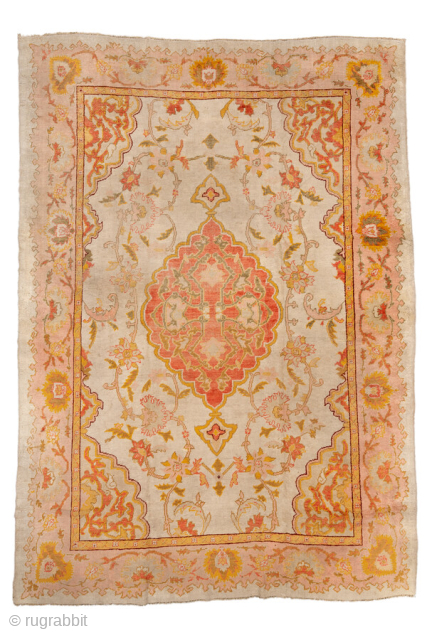 Antique Turkish Oushak Carpet, circa 1900. Featuring a softly drawn central medallion on a pale ivory field with warm coral, gold, and pastel accents, framed by a delicate floral border. Elegant, airy  ...
