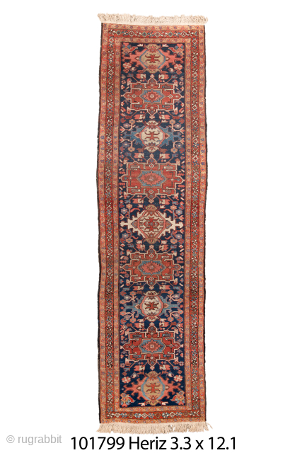 Antique Persian Heriz Runner, Circa 1910. Features a striking series of geometric medallions and stylized floral motifs woven on a deep navy-blue field. Bold drawing, rich colors, and robust construction characteristic of ...