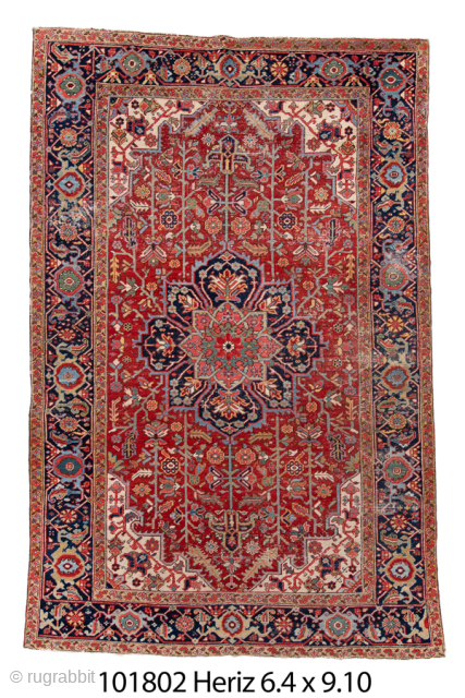 Antique Persian Heriz Rug, Circa 1910. Features a striking geometric medallion design woven in rich shades of red, navy, ivory, and soft blue. Showcases the bold drawing, durable construction, and distinctive village  ...
