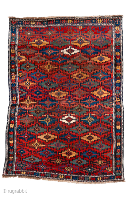 Antique Persian Kurdish Rug, Circa 1900. Vibrant allover lattice of hooked geometric medallions woven across a rich madder-red field framed by a bold indigo tribal border.

4'8" x 6'7"

Item No: 101377   