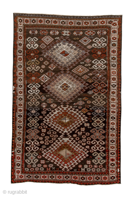 Antique Persian Kurdish Rug, Circa 1900. Bold stepped diamond medallions woven across a richly ornamented walnut-brown field framed by a crisp ivory tribal border.
4'6" x 7'0"
Item No: 97852