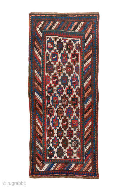 Antique Persian Kurdish Rug, Circa 1900. Vibrant ivory field filled with repeating geometric tribal motifs framed by dramatic barber-pole borders in rich madder red and indigo.
3'3" x 7'5"
Item No: 99592
