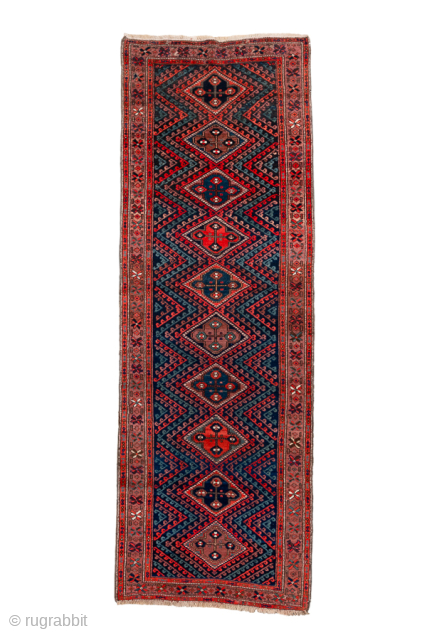 Antique Persian Kurdish Rug Runner, Circa 1900. Striking sequence of stepped diamond medallions connected by bold zigzag motifs woven across a rich midnight blue field framed by geometric tribal borders.
3'0" x 8'9"
Item ...