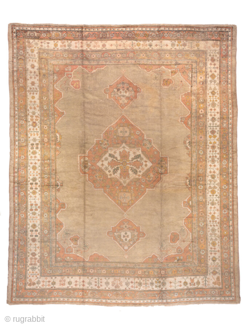 This exceptional antique Oushak rug, woven circa 1900, is a magnificent example of large-scale Anatolian weaving. Measuring over 13 × 16 feet, it features a grand central medallion design flanked by smaller  ...