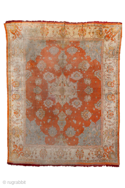 This impressive antique Oushak rug, measuring 13.5 x 17.0 feet, showcases the grandeur and artistry of late 19th to early 20th century Anatolian weaving. The rug features a bold central medallion set  ...