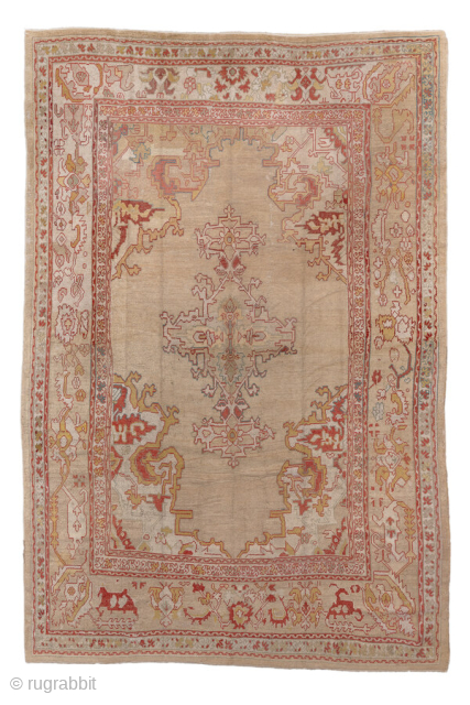 This antique Oushak rug from circa 1900 features a bold and spacious design, characteristic of the finest Anatolian weaving traditions. The soft beige-taupe field is anchored by a striking central medallion with  ...